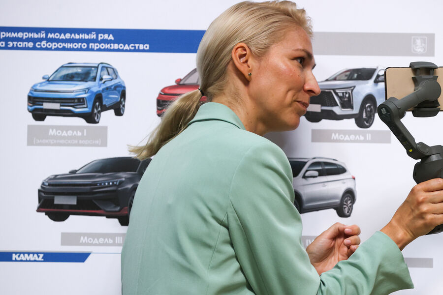 Женщина у&nbsp;примерного модельного ряда автомобилей на&nbsp;этапе сборочного производства на&nbsp;московском автомобильном заводе &laquo;Москвич&raquo;