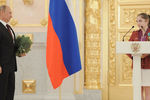 Президент России Владимир Путин на торжественной церемонии вручения государственных наград российским олимпийцам в Александровском зале Большого Кремлевского дворца. Справа — олимпийская чемпионка по спортивной гимнастике Алия Мустафина, 2012 год