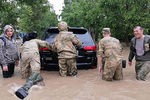 Военнослужащие помогают местному жителю толкать автомобиль на затопленной улице в Керчи, 17 июня 2021 год