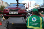 Сотрудник АМПП погружает автомобиль на эвакуатор