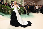 Николь Кидман появилась на Met Gala вместе с мужем Китом Урбаном. На бал она надела платье из белого шелкового бюстье и объемной юбки, расшитой «перьями» из органзы. Это вариант наряда, который в 1951 году придумал Кристобаль Баленсиага, созданный нынешним модельером Balenciaga Демной Гвасалией.
