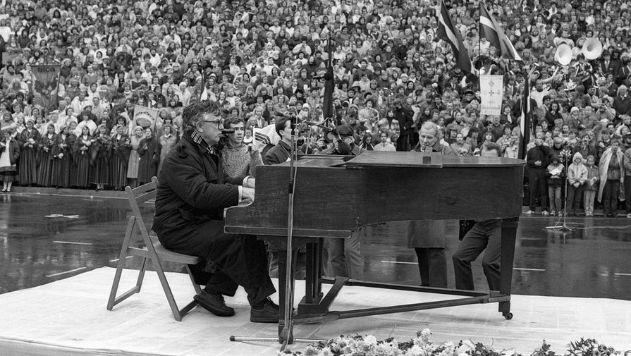 Композитор Раймонд Паулс аккомпанирует многотысячному хору участников манифестации в&nbsp;поддержку учредительного съезда Народного фронта Латвии в&nbsp;Межапарке города Риги, 1988&nbsp;год