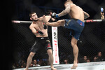 Чемпион UFC в легком весе Хабиб Нурмагомедов и временный чемпион UFC в легком весе Дастин Порье (слева направо) во время поединка за звание чемпиона UFC в легком весе на турнире UFC 242 по смешанным единоборствам на стадионе The Arena в Абу-Даби, 2019 год