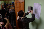 Женщина фотографирует списки пропавших без вести при пожаре, 26 марта 2018 года