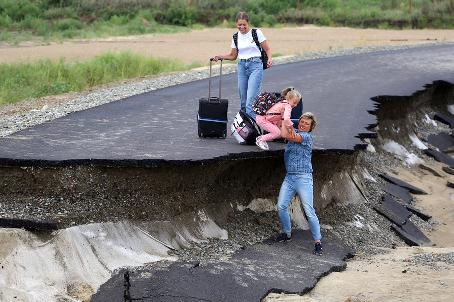 Семья добирается до&nbsp;аэропорта по&nbsp;размытой ливнями дороге А290 в&nbsp;районе села Цибанобалка в&nbsp;Краснодарском крае, 14&nbsp;августа 2021&nbsp;года
