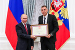 Президент РФ Владимир Путин и игрок сборной России по футболу Артем Дзюба, награжденный почетной грамотой, на церемонии вручения государственных наград в Екатерининском зале Кремля, 2018 год.