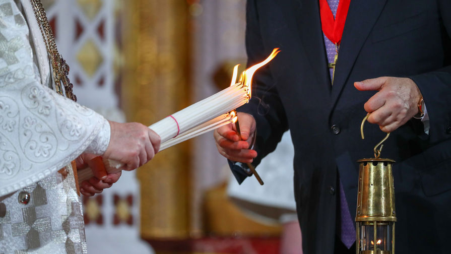 Патриарх Московский и всея Руси Кирилл и председатель попечительского совета Фонда Андрея Первозванного Владимир Якунин во время передачи Благодатного огня во время праздничного пасхального богослужения в храме Христа Спасителя, 28 апреля 2019 года
