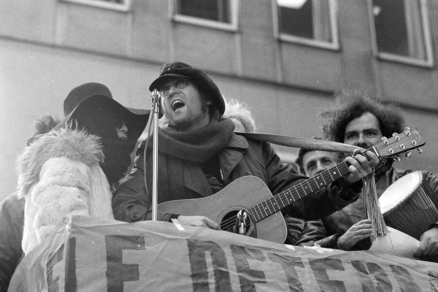 Экс-солист группы The Beatles Джон Леннон и его жена Йоко Оно поют во время демонстрации перед&nbsp;офисом British Overseas Airways Corp. на&nbsp;Пятой авеню в&nbsp;Нью-Йорке, 5&nbsp;февраля 1972&nbsp;года