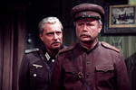 <b>Олег Басилашвили (Лахновский) и Юрий Смирнов (Полипов) в фильме «Вечный зов» (1973–1983).</b>
<br><br>
Следующей ролью Олега Басилашвили после «Возвращения «Святого Луки» стал образ следователя Охранного отделения, белогвардейца, а затем и предателя Арнольда Лахновского. Персонаж получился очень убедительным, хотя — благодаря природной интеллигентности актера — и более человечным, чем изначально в сценарии. Эта роль принесла Олегу Басилашвили большую известность.