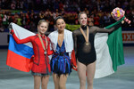Призеры женского одиночного катания на Чемпионате мира по фигурному катанию 2014 года в Сайтаме, во время церемонии награждения: Юлия Липницкая (Россия) — серебряная медаль, Мао Асада (Япония) — золотая медаль, Каролина Костнер (Италия) — бронзовая медаль