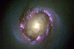 Снимок спиральной галактики с перемычкой NGC 4314, в которой видны яркие пурпурные области с молодыми звездами. 1998 год