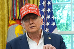 Президент Дональд Трамп в Овальном кабинете Белого дома показывает фото с Владимиром Путиным, Вашингтон, 22 августа 2025 года.