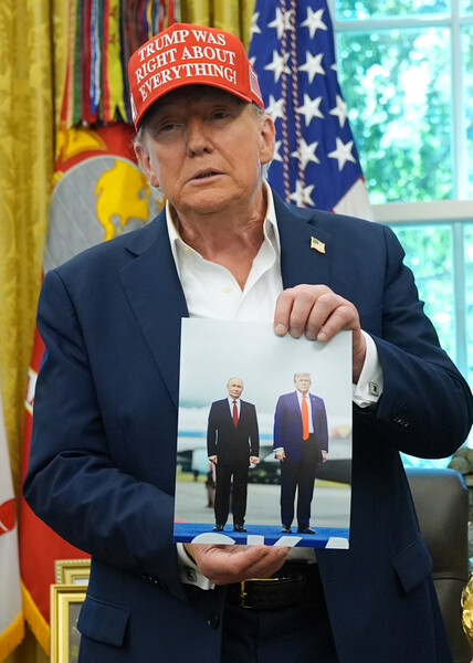 Президент Дональд Трамп в&nbsp;Овальном кабинете Белого дома показывает фото с&nbsp;Владимиром Путиным, Вашингтон, 22&nbsp;августа 2025&nbsp;года.