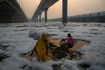 Люди во время религиозного праздника Чхат Пуджа возле священной реки Ямуна, покрытой слоем ядовитой пены, Нью-Дели, 10&nbsp;ноября 2021&nbsp;года