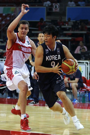 Южнокорейский форвард Донг-Гук Ким уходит от Александра Кауна