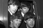 Группа The Beatles в окне вагона поезда перед отправлением с вокзала Паддингтон в Лондоне, 2 марта 1964 года