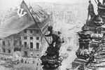 Бойцы 8-й гвардейской армии РККА Алексей Ковалев, Абдулхаким Исмаилов и Леонид Горичев (слева направо) с красным знаменем на крыше здания Рейхстага после взятия города советскими войсками, 2 мая 1945 года
