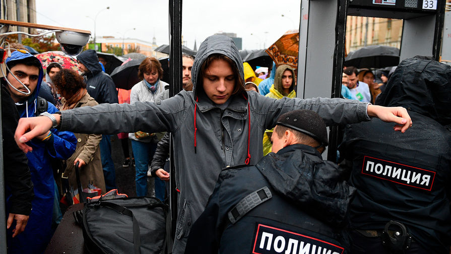 Cотрудник полиции досматривает участника митинга в поддержку незарегистрированных кандидатов в Мосгордуму на проспекте Академика Сахарова в Москве