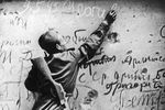 Советский солдат оставляет надпись на стене Рейхстага, май 1945 года