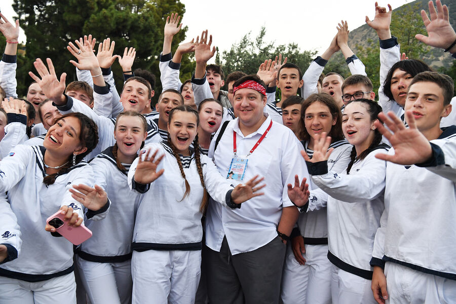 Актер Роман Попов (в центре) перед началом церемонии открытия Международного детского кинофестиваля «Алые паруса» имени Василия Ланового в международном детском центре «Артек» в Крыму, 2024 год