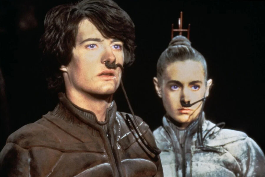 <b>“Дюна” (1984)</b>
<br><br>
Когда Тимоти Шаламе еще даже не было в&nbsp;планах у&nbsp;его родителей, на&nbsp;экранах уже вовсю шла “Дюна” – эпический блокбастер по&nbsp;мотивам одноименного романа Фрэнка Герберта. Вместо главного краша 20-х в&nbsp;роли Пола Атрейдеса там был молодой дебютант Кайл Маклахлен – огромный фанат книги, впервые прочитавший ее в&nbsp;14 лет, а затем ежегодно к&nbsp;ней возвращавшийся. Проект (как и все предыдущие и последующие попытки перенести великий бестселлер на&nbsp;экран) был крайне амбициозным и дорогим, однако успехом не увенчался: он провалился в&nbsp;прокате, заставил негодовать фанатов и стал одним из&nbsp;столпов легенды о&nbsp;проклятии романа на&nbsp;кинопоприще, развеять которую сумел лишь Дени Вильнев в&nbsp;2021 году. Впрочем, один огромный плюс у&nbsp;картины все же имелся — именно на&nbsp;съемках “Дюны” впервые поработали вместе тогда еще ноунейм Маклахлен и некий Дэвид Линч (который ради проекта отказался снимать “Звездные войны” – но это уже совсем другая история).
