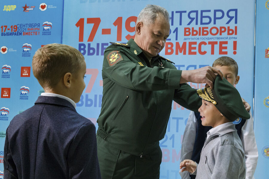Министр обороны России Сергей Шойгу надевает военную фуражку на&nbsp;мальчика после голосования на&nbsp;избирательном участке во время парламентских выборов в&nbsp;Москве,17 сентября 2021&nbsp;года
