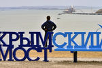 Скамейка «Крымский мост» на фоне железнодорожной арки моста через Керченский пролив, август 2017 года