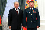 Президент России Владимир Путин и командир 37-й отдельной гвардейской мотострелковой бригады 36-й общевойсковой армии полковник Валерий Асапов, награжденный орденом «За заслуги перед Отечеством» IV степени, на церемонии вручения грамоты о присвоении Хабаровску почетного звания «Город воинской славы» и государственных наград в Кремле, февраль 2013 года