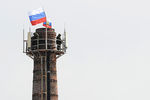 Военнослужащие охраняют российские флаги, водруженные на трубу котельной комплекса зданий штаба ВМС Украины