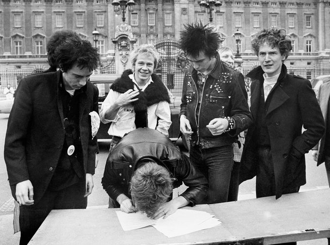 Группа Sex Pistols и их менеджер Малкольм Макларен (справа) подписывают договор со звукозаписывающей компанией у&nbsp;Букингемского дворца в&nbsp;Лондоне, 1977 год 