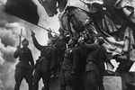 Советские воины салютуют Красному знамени, водруженному на здании Рейхстага, 9 мая 1945 года