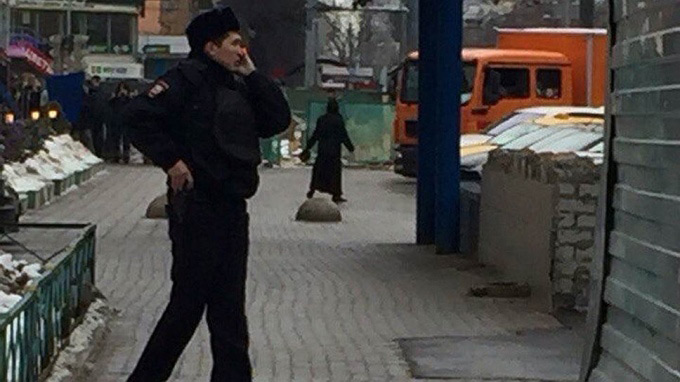 Женщина с головой ребенка в руке (на заднем плане) у станции «Октябрьское Поле» в Москве