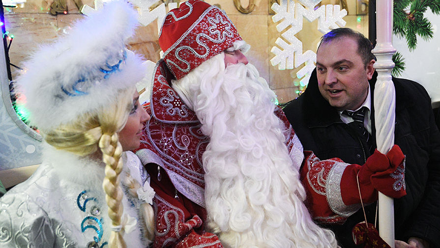 Начальник Московского метрополитена Дмитрий Пегов, Дед Мороз и Снегурочка на церемонии запуска новогоднего поезда московского метро, украшенного гирляндами и еловыми ветками