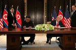 Высший руководитель КНДР Ким Чен Ын и президент США Дональд Трамп во время подписания документов на встрече в Сингапуре, 12 июня 2018 года