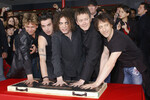Члены The Cure оставляют отпечатки рук во время участия в Rock Walk в Голливуде, 2004 год